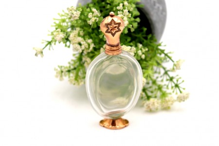 Frasco de perfume em vidro com base e tampa em ouro com relevos